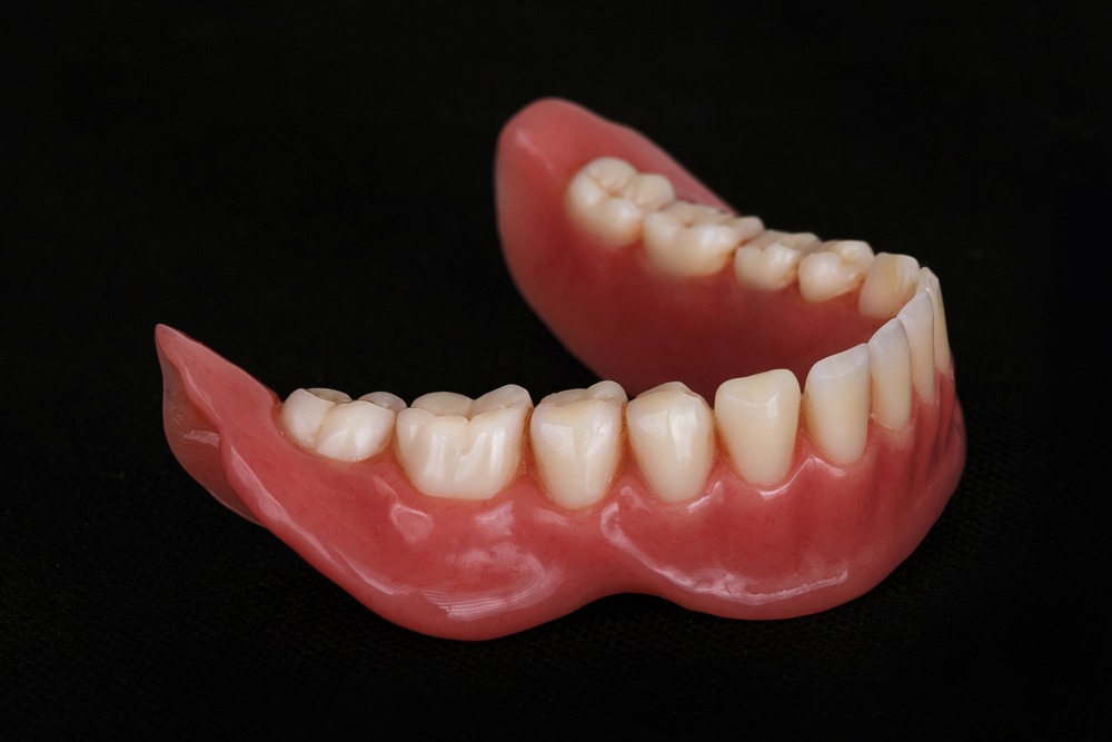 New set of lower dentures sitting on a black canvas.