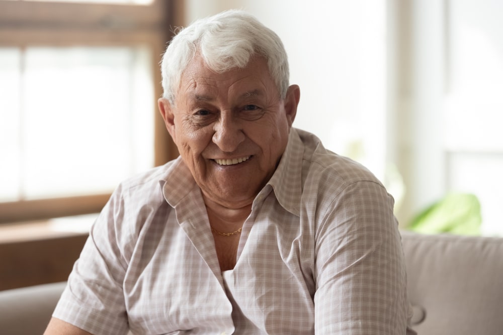 elderly man smiles with dentures