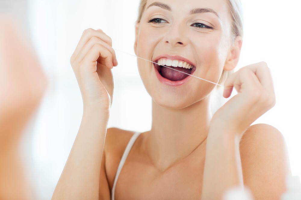 woman flossing teeth for oral health