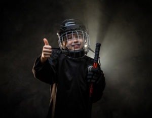 a young female hockey player giving a thumbs up