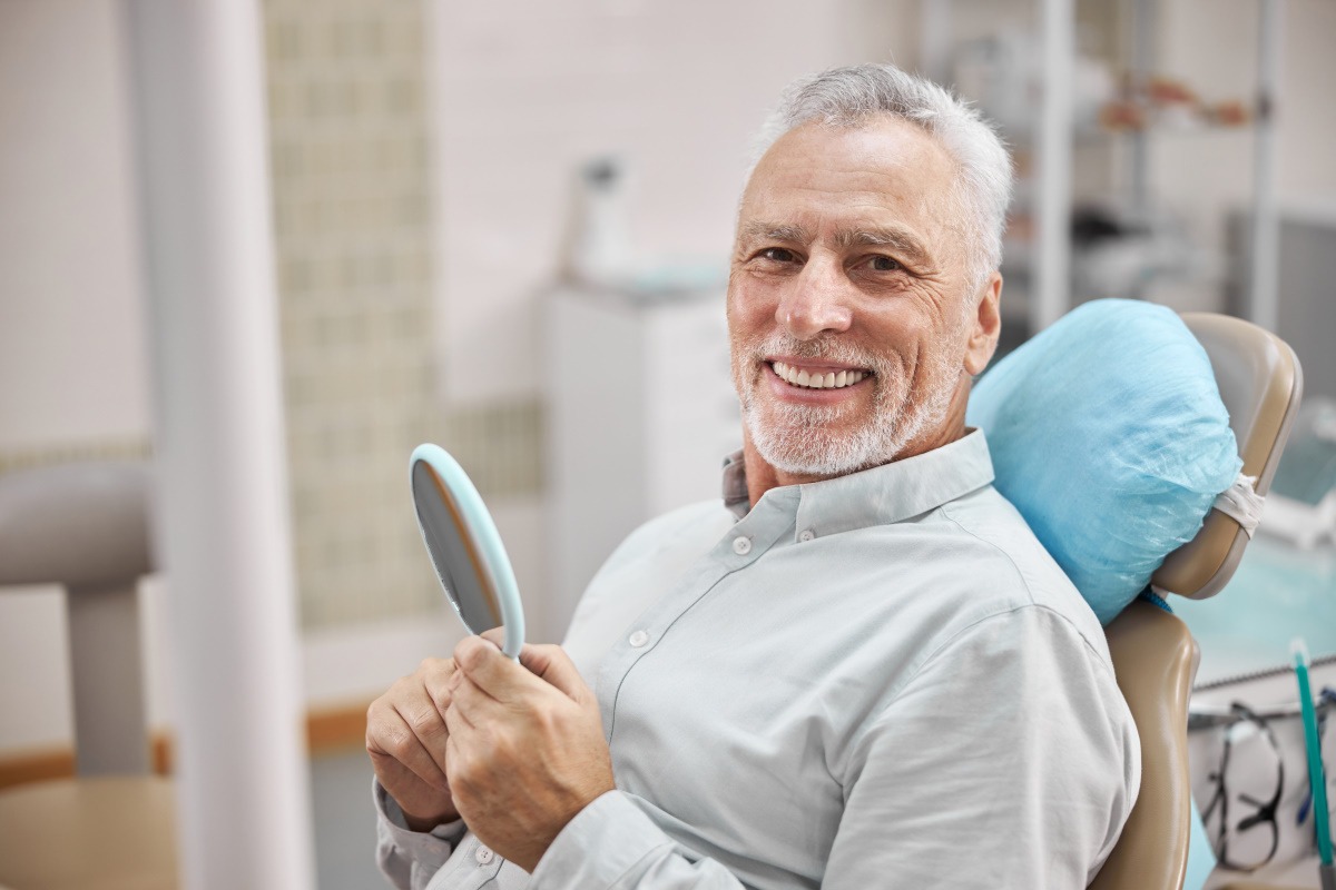 older man smiling with new dentures