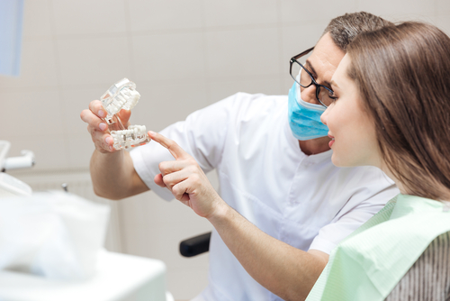 denturist and patient looking at dentures